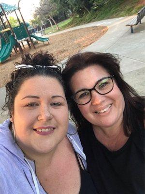 Me and my cousin on a picnic bench while my littles play close by