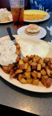 Chicken fried steak, home fries, and  over med egg