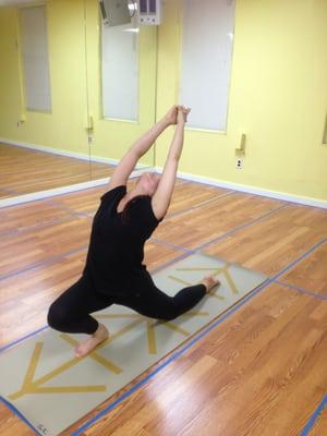 Low lunge with upward stretch right leg forward. she's been doing hotyoga for 6months.