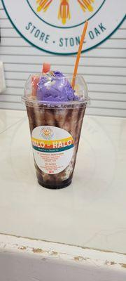 Halo halo containing a mixture of shaved ice, ube ice cream, red beans, jellies, pokie sticks, chocolate syrup and more.