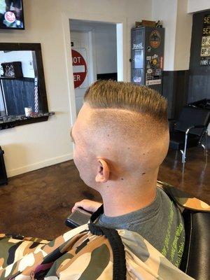 Mid-High bald fade with hard part.