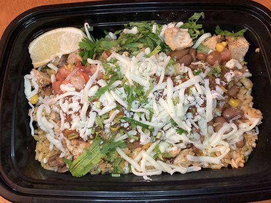 Chicken burrito bowl with mexican rice, pinto beans, pico de gallo, corn salsa, mild salsa, cilantro, & lime wedge.