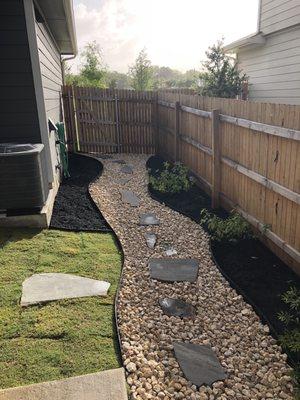 After - gravel and flagstone walkway, more Bermuda sod, and flower beds installed