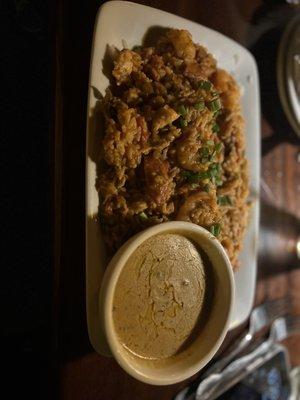 Jambalaya with rice with a side of Louisiana sauce