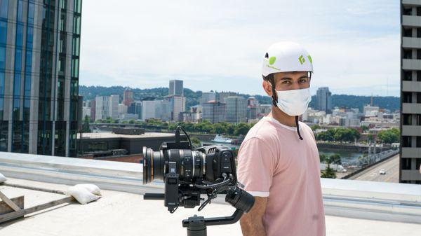 A Bridge City Media videographer appears in safety gear while on a rooftop shoot.