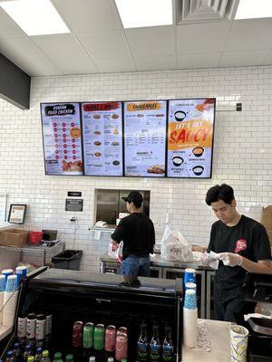 The menu board and the 2 workers manning the front