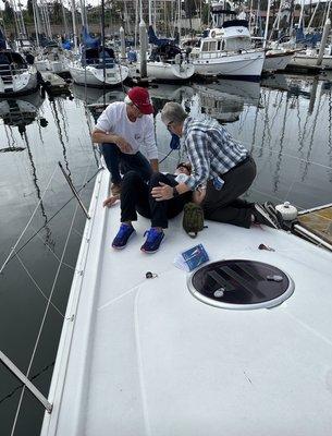 Assessing the victim on the bow of a sail boat.