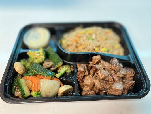 Hibachi steak with fried rice and vegetables.