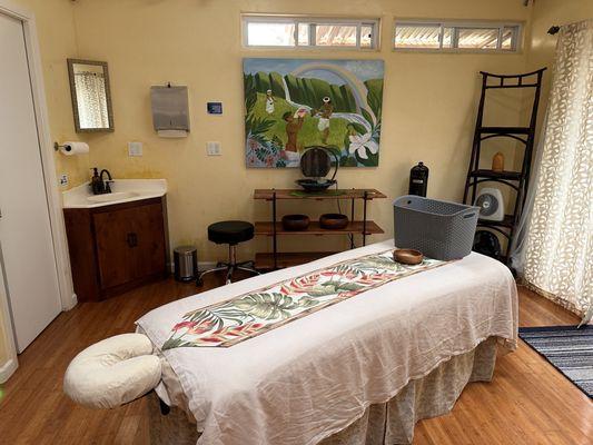 Massage room with hot soak tub inside it.