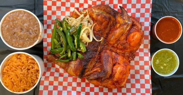 Whole Ranchero Chicken Combo with grilled onions, jalapeños, rice, beans, tortillas, and your choice of red or green salsa.