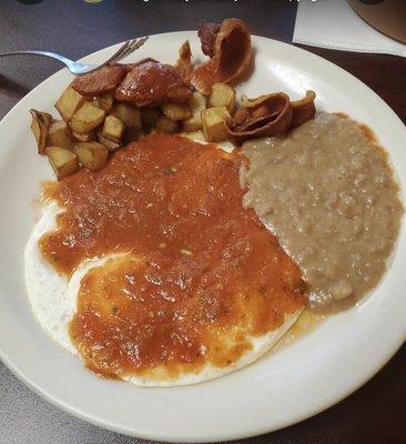 Huevos Rancheros, pan fried potatoes , and refried beans.