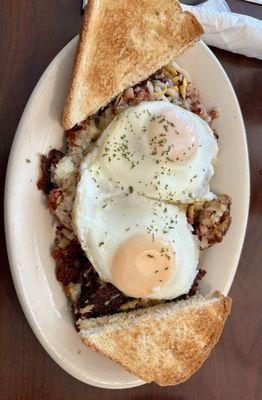 Corned beef hash skillet with basted eggs and white toast