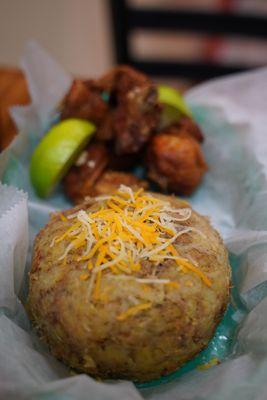 A dominican style mofongo with shredded cheese and fried chicken