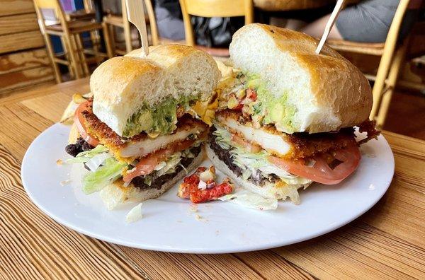 Fiesta Torta: chicken Milanese, refried black beans, lettuce, tomato, guacamole, corn relish, Flamin' Hot Cheetos