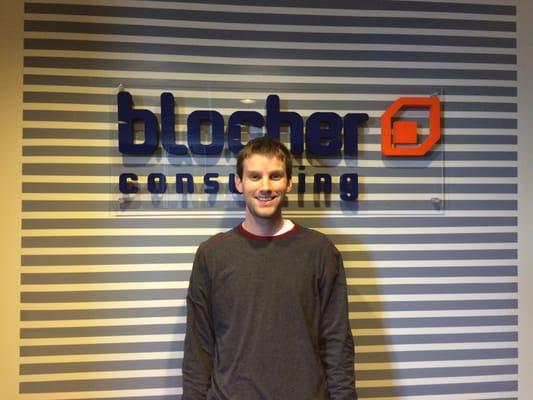 One of our talented PhDs standing in front of the new sign.