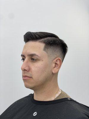 Combover and mid bald drop fade with a hard part and eyebrows cleaned up.