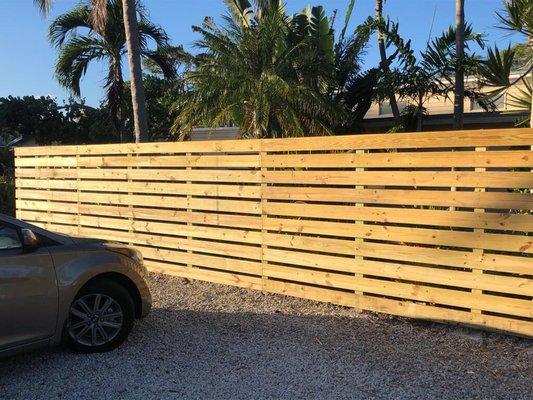 Wood Horizontal Fence: One sided fence with 2-1/2" spacing between horizontal members.