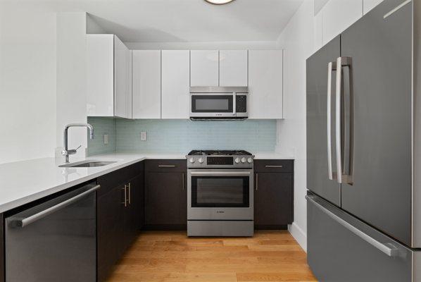 Renovated Open Kitchen with Lacquer Cabinets, Quartz Counter tops, Upgraded Appliances, and New Floors (2 Bedroom '09 Line)