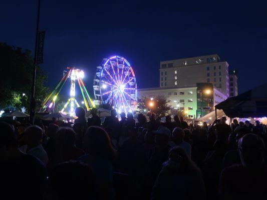 From the main stage audience, an evening view towards the rides.