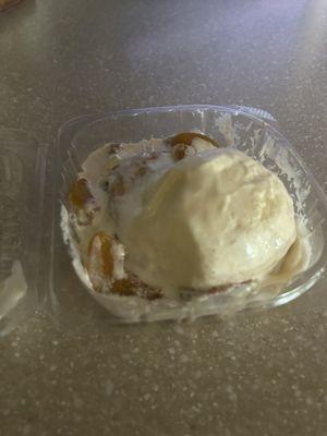 Peach cobbler: cinnamon roll topped with peaches and vanilla ice cream.