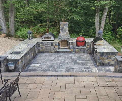 Outdoor kitchen with fireplace faced in thin stone