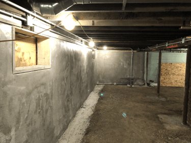 New foundation wall construction in a basement with fresh concrete.