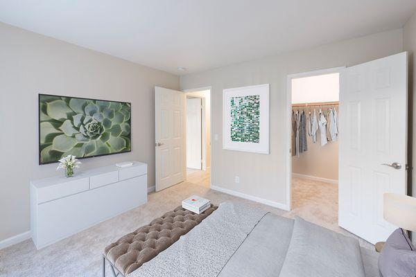 Spacious bedroom with staged furniture and walk-in closet.