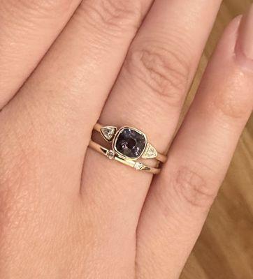 Custom made 14kt yellow gold ring, with bezel set cushion cut purple spinel and bezel set trillion diamond accents.