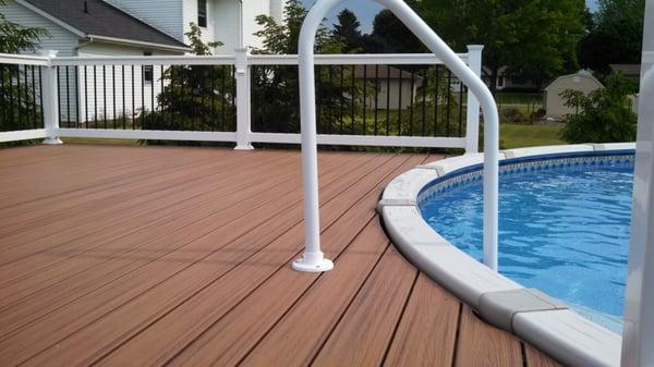 Pool deck with Trex Trandscends decking and white vinyl railing with Deckorator black aluminum balusters built in Canton, Ohi...