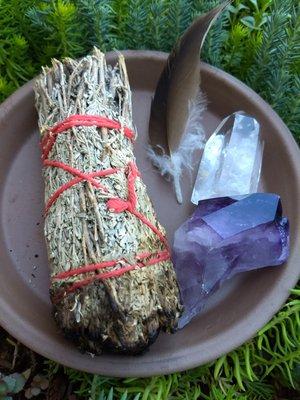 Desert sage for smudging, with feather and amethyst and quartz crystals.