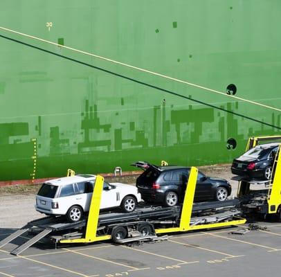 SUV's being loaded onto an open carrier