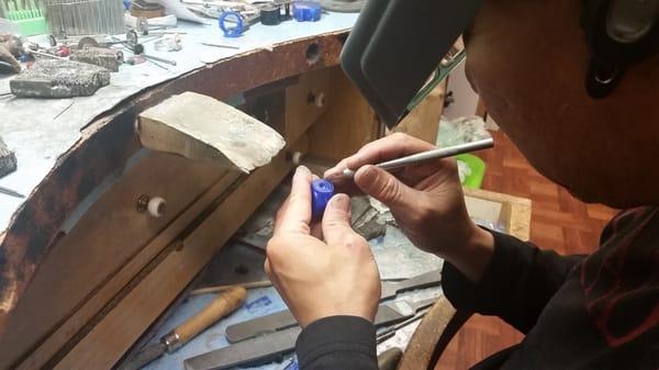 In house jeweler hand carving a wax sample for a custom ring