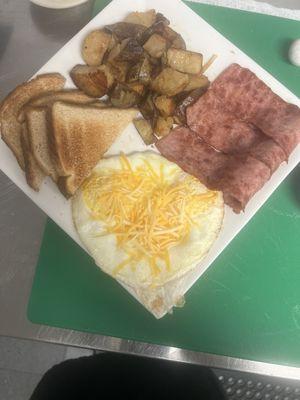 Turkey bacon, house fries, eggs and cheese on top with white toast