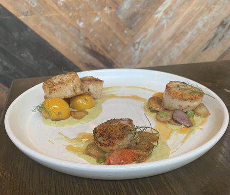 Seared scallops with heirloom tomatoes, pea puree, and fingerlings