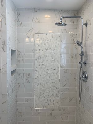 We chose these tiles with a pencil to make a mosaic pattern in the shower along with a custom tile base and marble threshold