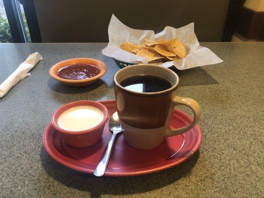 Coffee with milk, chips and salsa.