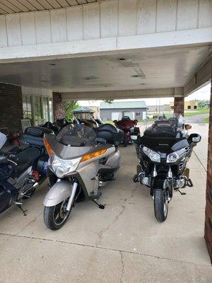 Group of riders bikes under front canopy.