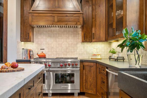 Kitchen with warm wood cabinets and hand painted backsplash