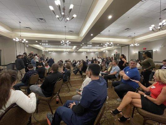 A room of people celebrating the last class of basic graduates