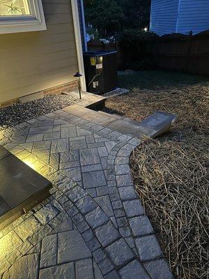 Steps from patio to side yard with lighting