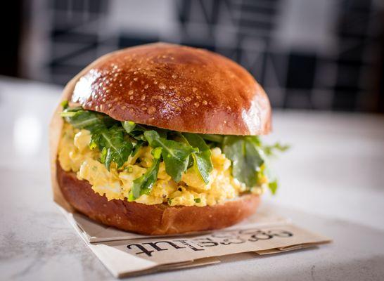 Egg Salad Sandwich (hard cooked eggs, chives, honey mustard aioli, topped
 with dressed arugula in a warm brioche
 bun)