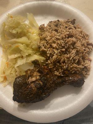 Jerk chicken, peas and rice with cabbage.