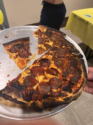 Burnt pizza. "That's just how it comes out. Sometimes it comes out fine and sometimes it comes out burn. Sorry"