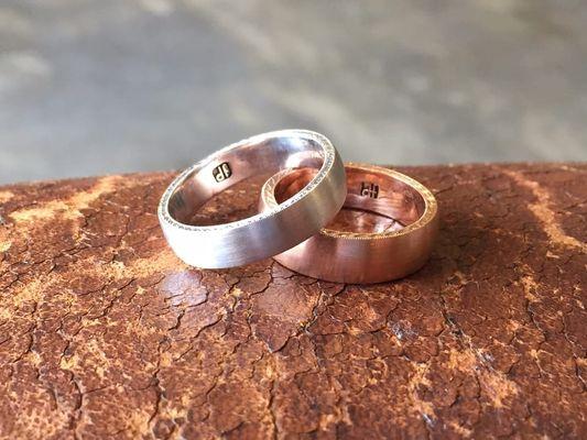 In platinum, and 18K rose gold, these slightly rounded bands have hand engraved sides and brushed finishes.