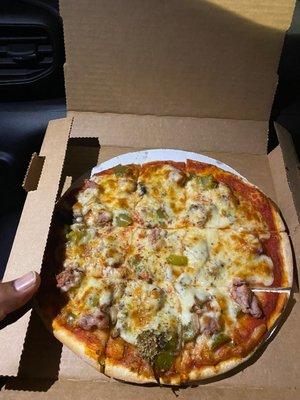 Green pepper, sausage and mushroom individual pizza.