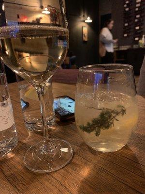 Glass of Pinot Grigio and wine spritzer with thyme or rosemary