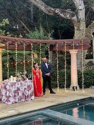 Curtain lighting behind sweetheart table and custom tree trunk wrap with twinkle lights