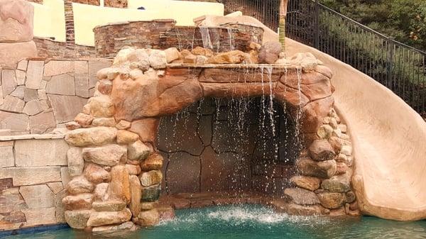 Cave with slide and overflowing jacuzzi on top.