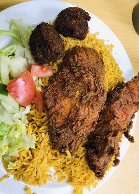 Fish over rice with a side of falafel and salad