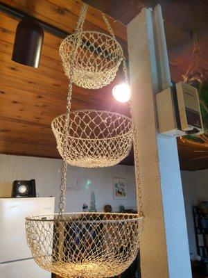 Layers of greasy dust on a hanging fruit basket which is directly above a food prep area